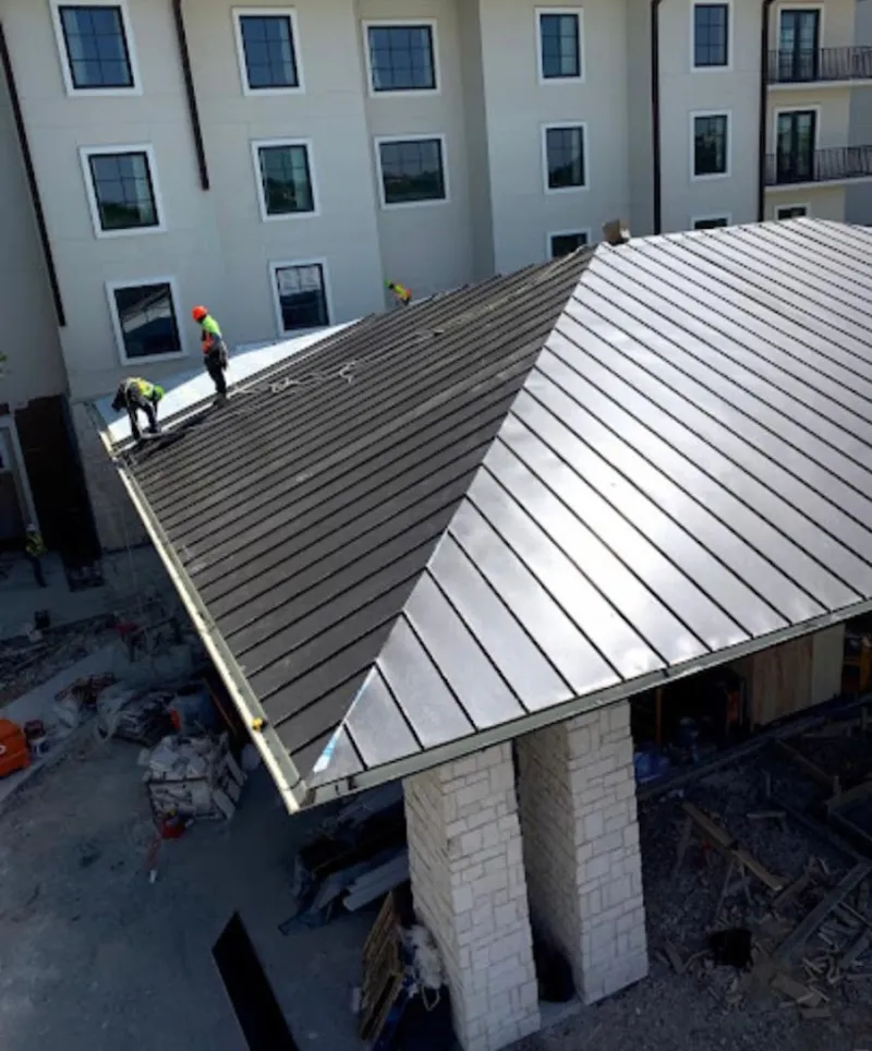 Crew installing standing seam metal roof panels on a commercial project in Chino Valley